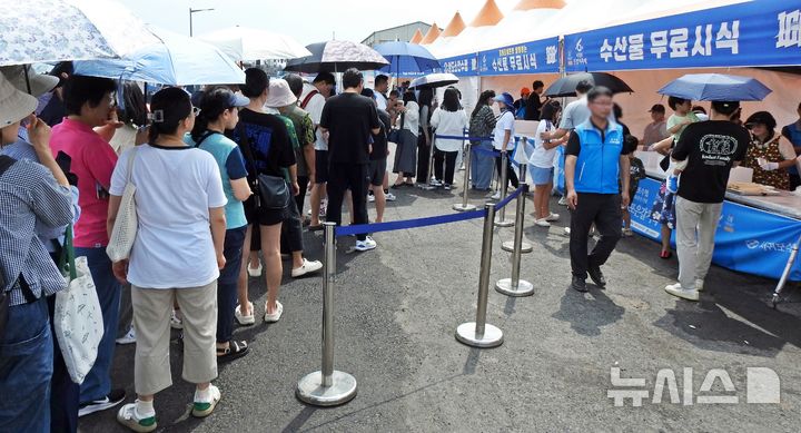 [제주=뉴시스] 오영재 기자 = 14일 오전 제주 서귀포시 서귀포항 동부두에서 열린 제6회 서귀포은갈치축제에서 방문객들이 은갈치 무료 시식 부스 앞에서 대기하고 있다. 2025.09.14. oyj4343 