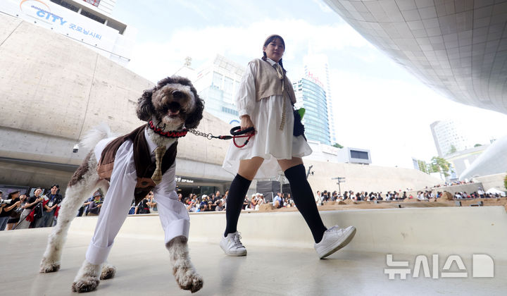 [서울=뉴시스] 홍효식 기자 = 14일 서울 중구 동대문디자인플라자(DDP) 어울림광장에서 열린 '댕댕 런웨이'에서 반려견들이 반려인과 제로웨이스트 패션쇼를 하고 있다. 2025.09.14. yesphoto@newsis.com