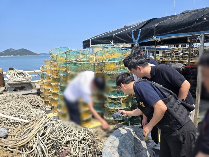 군산해경이 어선에 실린 통발의 표식을 확인하고 있다. (사진=군산해경 제공) *재판매 및 DB 금지