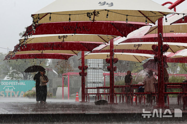 [서울=뉴시스] 권창회 기자 = 16일 오후 서울 종로구 광화문광장 인근에 소나기가 내려 시민들이 그늘 아래 비를 피하고 있다. 2025.09.16. kch0523@newsis.com