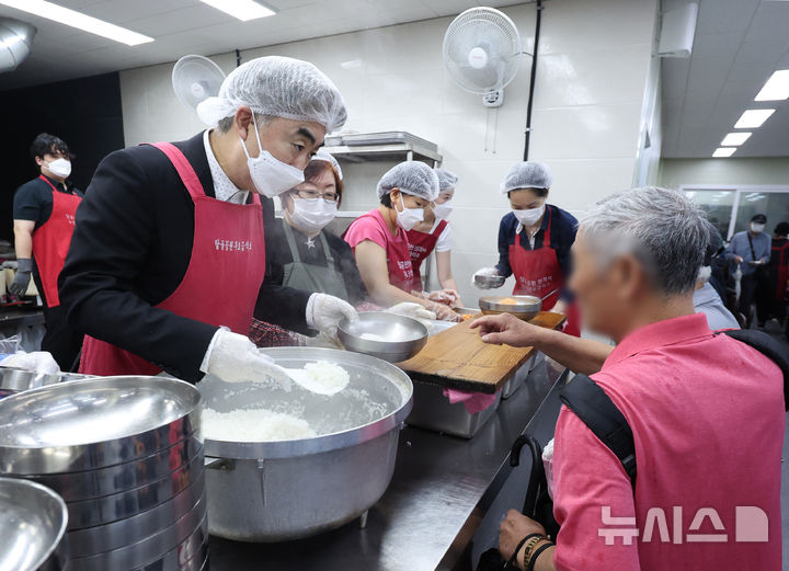 [서울=뉴시스] 김진아 기자 = 염영남(왼쪽) 뉴시스 대표이사와 임직원들로 구성된 자원봉사단이 17일 서울 종로구 탑골공원 원각사 무료급식소에서 점심 배식 봉사를 하고 있다. 2025.09.17. bluesoda@newsis.com