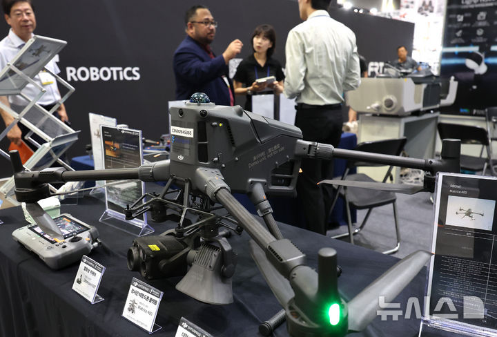 [고양=뉴시스] 전진환 기자 = 17일 오후 경기도 고양시 킨텍스에서 열린 2025 한국건설 안전박람회를 찾은 관람객이 실시간 대기오염 물질 감시 드론에 대한 설명을 듣고 있다. 2025.09.17. amin2@newsis.com