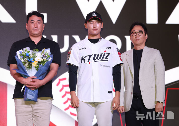 [서울=뉴시스] 황준선 기자 = 17일 오후 서울 송파구 롯데호텔월드에서 열린 2026 KBO 신인 드래프트에서 kt위즈 1라운드 지명된 전주고 박지훈(가운데)이 기념촬영 하고 있다. 왼족부터 박지훈 아버지, 박지훈, kt위즈 나도현 단장. 2025.09.17. hwang@newsis.com