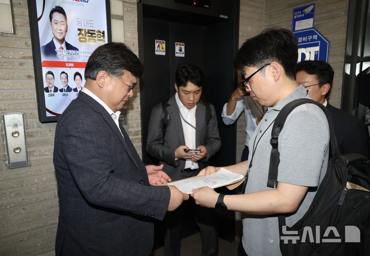 [서울=뉴시스] 조성봉 기자 = 김건희 여사의 의혹들을 수사하는 민중기 특별검사팀이 '통일교 집단 입당' 의혹과 관련해 18일 오전 서울 여의도 국민의힘 중앙당사를 압수수색하기 전 변호사에게 영장을 제시하고 있다.2025.09.18. suncho21@newsis.com