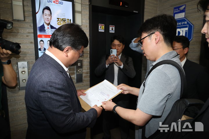 [서울=뉴시스] 조성봉 기자 = 김건희 여사의 의혹들을 수사하는 민중기 특별검사팀이 '통일교 집단 입당' 의혹과 관련해 18일 오전 서울 여의도 국민의힘 중앙당사를 압수수색하기 전 변호사에게 영장을 제시하고 있다.2025.09.18. suncho21@newsis.com