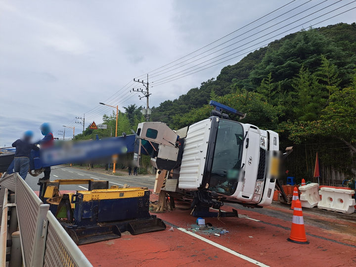 [부산=뉴시스] 18일 오후 부산 강서구의 한 도로에서 하수관 공사작업 중이던 카고 크레인이 중심을 잃고 오른쪽으로 넘어졌다. (사진=부산경찰청 제공) 2025.09.18. photo@newsis.com *재판매 및 DB 금지