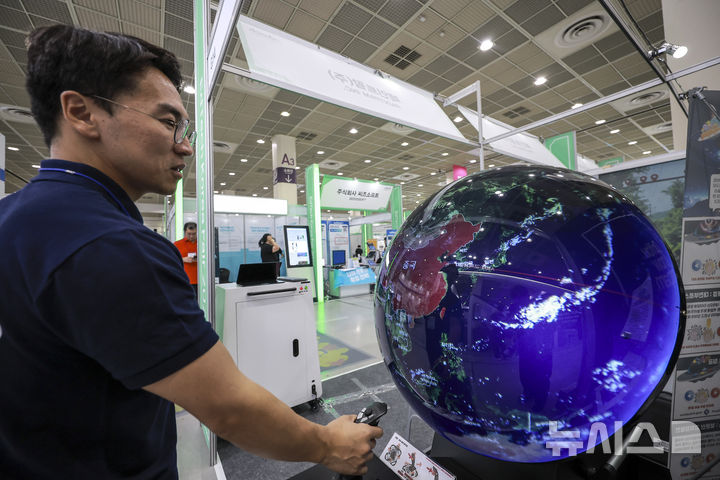 [서울=뉴시스] 정병혁 기자 = 18일 서울 강남구 코엑스에서 열린 에듀테크 코리아 페어에서 참관객이 구형 디스플레이로 세계지도를 살펴보고 있다. 2025.09.18. jhope@newsis.com