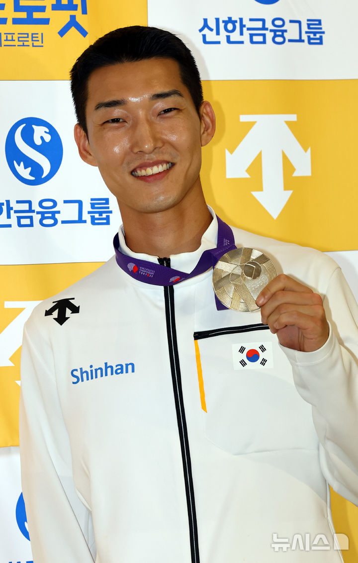 [서울=뉴시스] 박주성 기자 = 2025 도쿄 세계육상선수권대회 남자 높이뛰기에서 은메달을 획득한 우상혁 선수가 18일 서울 강서구 김포국제공항 입국장으로 귀국해 취재진에게 은메달을 들어보이고 있다. 2025.09.18. park7691@newsis.com