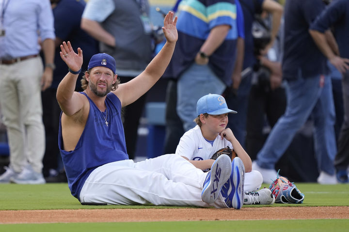 [로스앤젤레스=AP/뉴시스] 로스앤젤레스(LA) 다저스의 클레이튼 커쇼(37)가 18일(현지 시간) 미 캘리포니아주 LA 다저 스타디움에서 2025 MLB 샌프란시스코 자이언츠와의 경기에 앞서 은퇴를 발표한 후 아들 찰리와 함께 운동장에 앉아 있다. LA 다저스의 살아있는 전설 커쇼는 이번 시즌을 끝으로 은퇴한다고 밝혔다. 그는 19일 샌프란시스코와의 홈경기에 마지막 선발로 나선다. 2025.09.19.