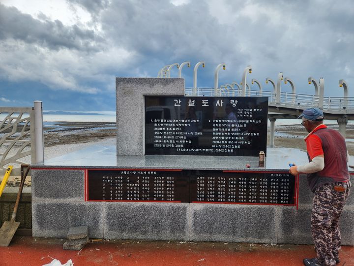 [서산=뉴시스] 한 작업자가 지난 16일 서산 대표 관광지인 간월도 탐방로 주변에 간월도사랑 노래비를 설치하고 있다. (사진=독자 제공) 2025.09.19. photo@newsis.com *재판매 및 DB 금지