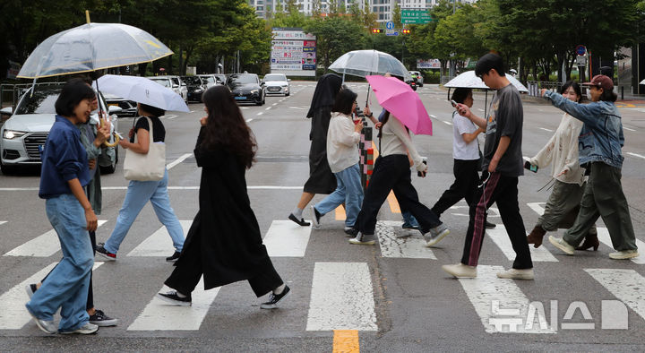 [서울=뉴시스] 김혜진 기자 = 비가 내리는 19일 오후 서울 마포구 상암동 인근에서 우산을 쓴 시민들이 이동하고 있다. 2025.09.19. jini@newsis.com