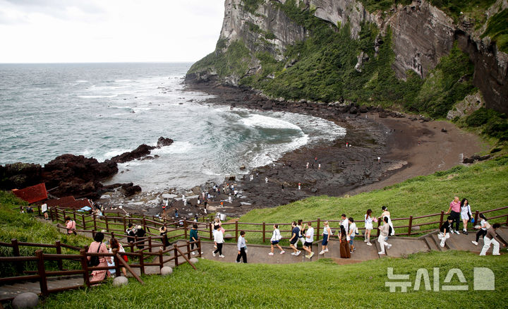 [서귀포=뉴시스] 우장호 기자 = 흐린 날씨를 보인 지난 19일 오후 제주 서귀포시 성산일출봉에 외국인 관광객들이 찾아와 기암절경을 감상하고 있다. 2025.09.19. woo1223@newsis.com