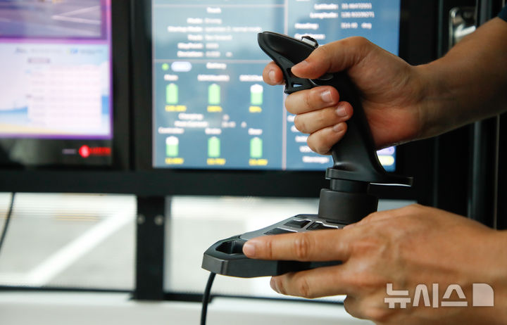 [서귀포=뉴시스] 우장호 기자 = 19일 오후 제주 서귀포시 성산읍 광치기해변 일원에서시범 운행에 나선 관광형 자율주행버스 '일출봉 GO'에서 안전관리자가 핸들 대신 조이스틱으로 보조 운행 시범을 보이고 있다. 핸들과 페달이 없이 이동하는 레벨4(Lv4) 수준의 '일출봉 GO'는 오는 22일부터 12월19일까지 섭지코지, 신양해수욕장, 광치기해변, 성산일출봉(성산수협 앞)을 잇는 왕복 9.3㎞ 구간에서 시범 운행된다. 2025.09.19. woo1223@newsis.com