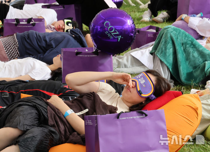 [서울=뉴시스] 배훈식 기자 = 2025 한강 잠퍼자기 대회가 열린 20일 오후 서울 여의도 한강공원에서 참가자들이 낮잠을 자고 있다. 2025.09.20. dahora83@newsis.com