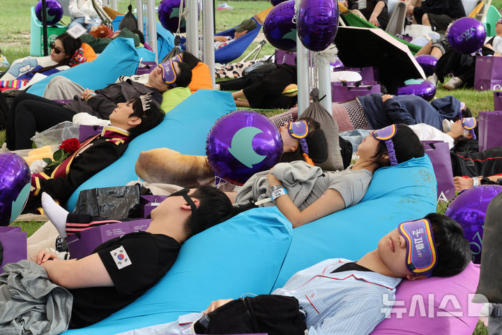 [서울=뉴시스] 배훈식 기자 = 2025 한강 잠퍼자기 대회가 열린 20일 오후 서울 여의도 한강공원에서 참가자들이 낮잠을 자고 있다. 2025.09.20. dahora83@newsis.com