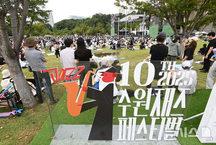 [수원=뉴시스] 김종택 기자 = 2025 수원재즈페스티벌 둘째날인 20일 오후 경기 수원시 광교호수공원 재미난 밭에서 잔디광장을 가득 메운 시민들이 선선한 가을 공기를 맞으며 흥겨운 재즈 선율을 즐기고 있다. 2025.09.20. jtk@newsis.com