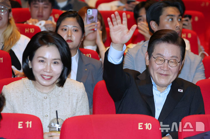[부산=뉴시스] 최동준 기자 = 이재명 대통령과 김혜경 여사가 20일 부산 해운대구 영화의전당에서 부산국제영화제 공식상영작 '극장의 시간들' 관람에 앞서 관객들에게 인사하고 있다. (대통령실통신사진기자단) 2025.09.20. photocdj@newsis.com
