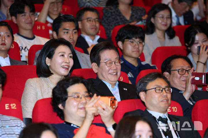 [부산=뉴시스] 최동준 기자 = 이재명 대통령과 김혜경 여사가 20일 부산 해운대구 영화의전당에서 부산국제영화제 공식상영작 '극장의 시간들'을 관람한 뒤 감독과 배우들을 보며 밝게 웃고 있다. (대통령실통신사진기자단) 2025.09.20. photocdj@newsis.com