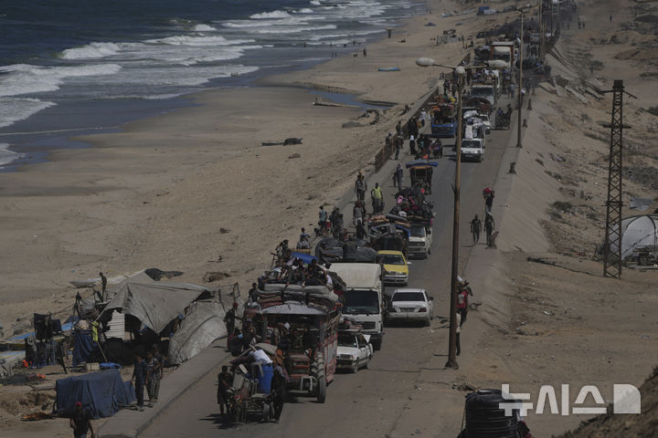 [AP/뉴시스] 가자 북부에서 팔레스타인 사람들이 20일 지중해변 길을 따라 남으로 이동하고 있다. 중부 와디 가자 인근.