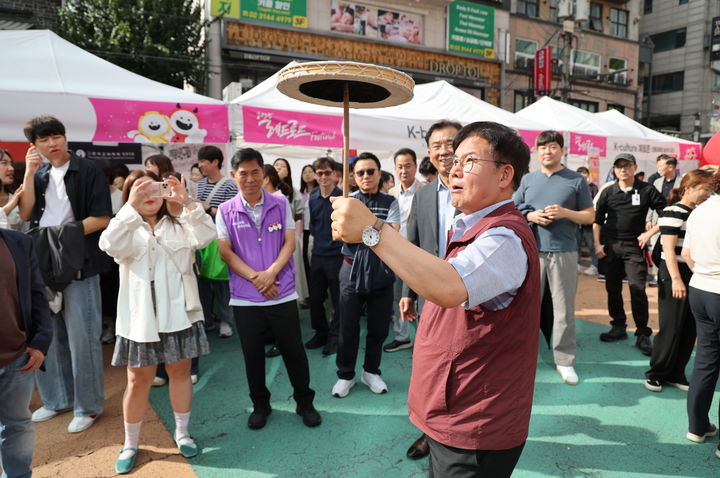 [서울=뉴시스] 레드로드 페스티벌에서 전통놀이 체험을 하는 박강수 마포구청장. 2025.09.21. (사진=마포구 제공) *재판매 및 DB 금지