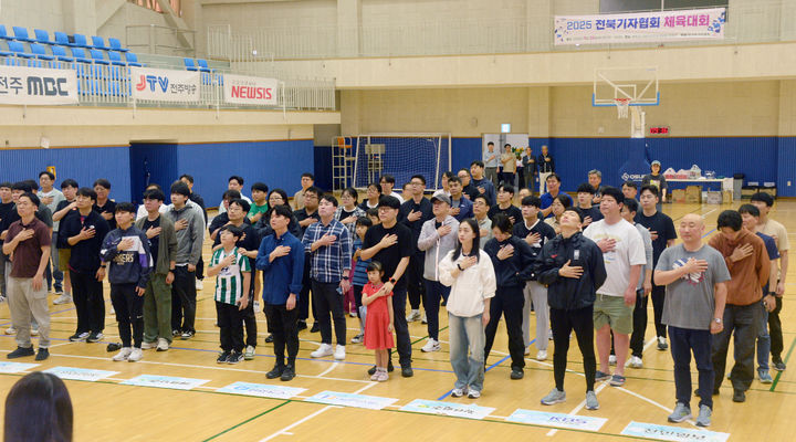 [완주=뉴시스] 지난 20일 전북 완주군 지방자치인재개발원에서 진행된 '2025 전북기자협회 체육대회' 진행 전 체육대회에 참여한 협회원들이 국민의례를 하고 있다. (사진=전북사진기자협회 제공) 2025.09.21. photo@newsis.com *재판매 및 DB 금지