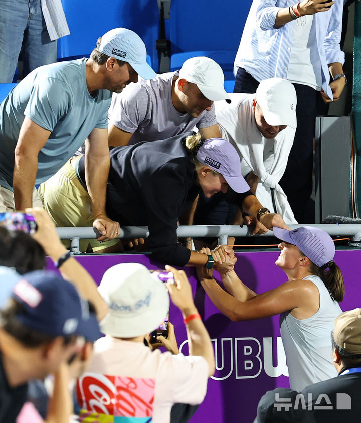 [서울=뉴시스] 최진석 기자 = 21일 서울 올림픽공원 테니스장에서 열린 2025 여자프로테니스(WTA) 투어 코리아오픈 단식 결승 이가 시비옹테크(폴란드)와 에카테리나 알렉산드로바(러시아)의 경기에서 승리를 거두며 우승을 차지한 시비옹테크가 팀원들과 기뻐하고 있다. 2025.09.21. myjs@newsis.com