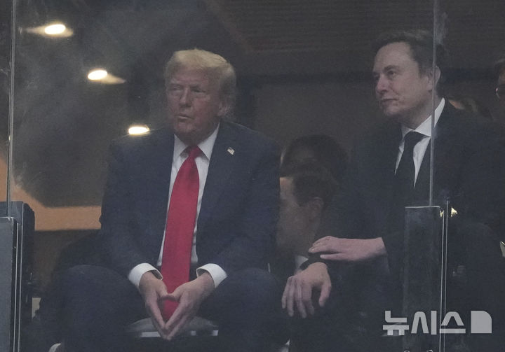 [글렌데일=AP/뉴시스] 도널드 트럼프 미국 대통령이 21일(현지 시간) 애리조나주 글렌데일 스테이트팜 스타디움에서 열린 보수 성향 활동가 찰리 커크 추모 행사에 참석해 일론 머스크 테슬라 최고 경영자와 얘기하고 있다. 2025.09.22.