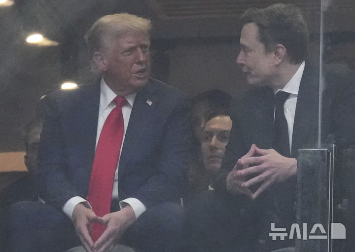 [글렌데일=AP/뉴시스] 도널드 트럼프 미국 대통령이 21일(현지 시간) 애리조나주 글렌데일 스테이트팜 스타디움에서 열린 보수 성향 활동가 찰리 커크 추모 행사에 참석해 일론 머스크 테슬라 최고 경영자와 얘기하고 있다. 2025.09.22.