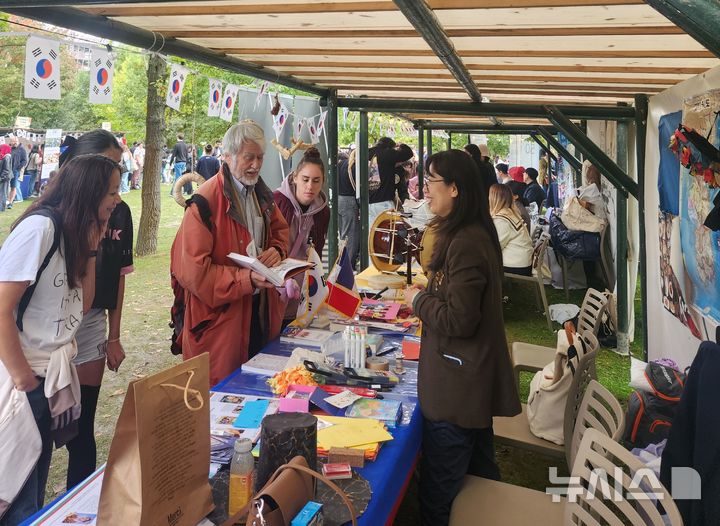 [파리=뉴시스]경남도 파리사무소 관계자가 프랑스 파리16구 아끌리마따시옹 공원(Jardin d’Acclimatation)에서 지난 20일부터 21일까지 열린 '2025년 프랑스 한가위 축제' 경남 홍보부스에서 경남 대표 관광지와 문화 콘텐츠를 홍보하고 있다.(사진=경남도 제공) 2025.09.22. photo@newsis.com