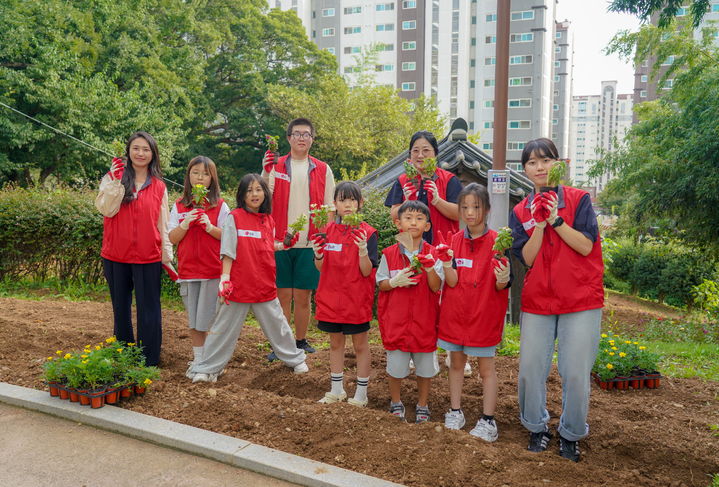 [여수=뉴시스] 여수시 이충무공 자당기거지 앞에서 지역아동센터 아동들과 행사 관계자들이 커피박 화분을 들고 기념사진 찍고 있다. (사진=여수시 제공) 2025.09.22. photo@newsis.com *재판매 및 DB 금지