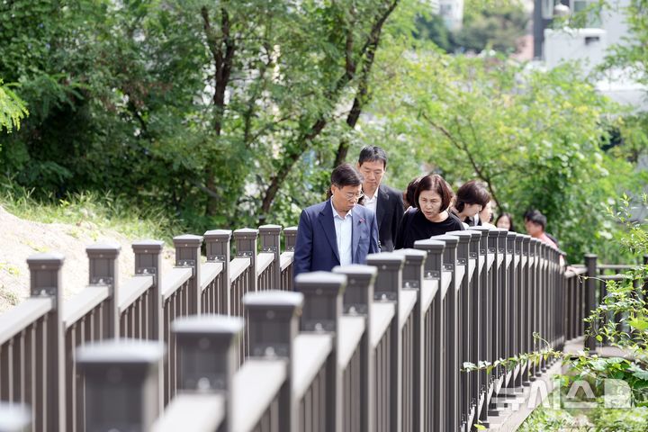 [성남=뉴시스] 신상진 성남시장이 22일 성남혜은학교에서 단대근린공원과 학교를 연결하는 안전보행로(목재데크) 완공 현장을 방문해 시설을 점검하고 있다(사진=성남시 제공) 2025.09.22.photo@newsis.com