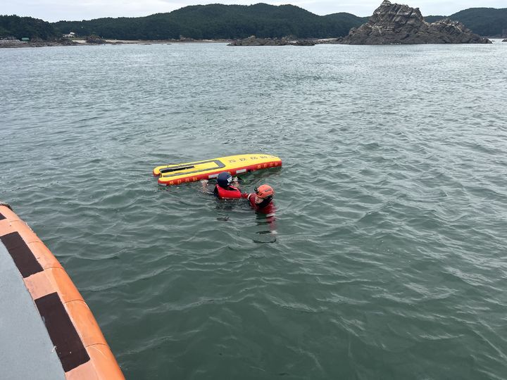 [태안=뉴시스] 태안해경이 22일 오후 충남 태안군 이원면 꽤깔섬 갯바위에 고립된 50대를 동력구조보드를 이용해 구조하며 연안구조정으로 옮기고 있다. (사진=태안해양경찰서 제공) 2025.09.22. photo@newsis.com *재판매 및 DB 금지