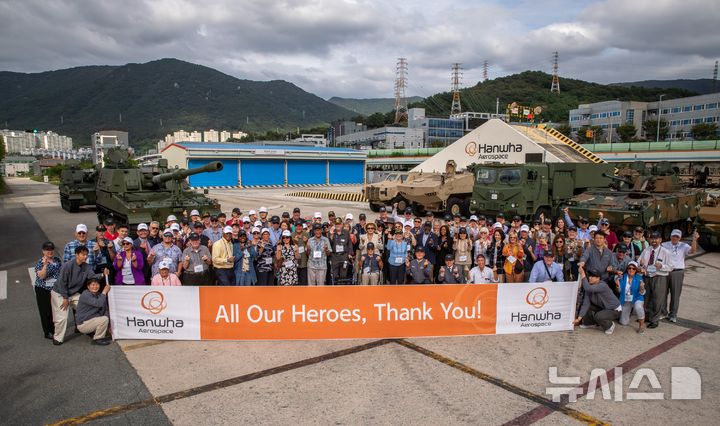 [창원=뉴시스]지난 19일 한화에어로스페이스 창원2사업장에서 진행된 '참전용사 재방한 행사'에서 6·25전쟁 미국 참전용사, 주한미군 소속 장병과 가족 등이 K9 자주포 등 주요 무기체계 앞에서 기념촬영하고 있다.(사진=한화에어로스페이스 제공) 2025.09.22. photo@newsis.com