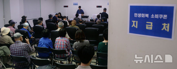 [전주=뉴시스] 김얼 기자 = 민생회복 소비쿠폰 2차 신청 첫날인 22일 전북 전주시 완산구 서신동 주민센터를 찾은 시민들이 쿠폰을 받기 위해 대기하고 있다. 2025.09.22. pmkeul@newsis.com