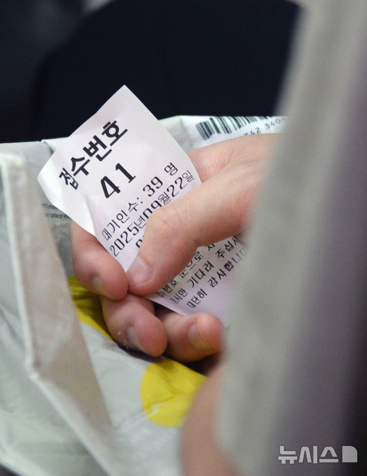 [전주=뉴시스] 김얼 기자 = 민생회복 소비쿠폰 2차 신청 첫날인 22일 전북 전주시 완산구 서신동 주민센터를 찾은 한 시민이 쿠폰을 받기 위해 대기하고 있다. 2025.09.22. pmkeul@newsis.com