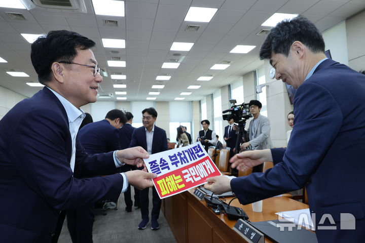 [서울=뉴시스] 김금보 기자 = 서범수 국회 행정안전위원회 국민의힘 간사가 22일 오전 서울 여의도 국회에서 열린 전체회의에서 여당의 정부조직법 일부개정법률안 졸속 추진을 규탄하는 피켓을 윤건영 더불어민주당 간사에게 전달하고 있다. 2025.09.22. kgb@newsis.com