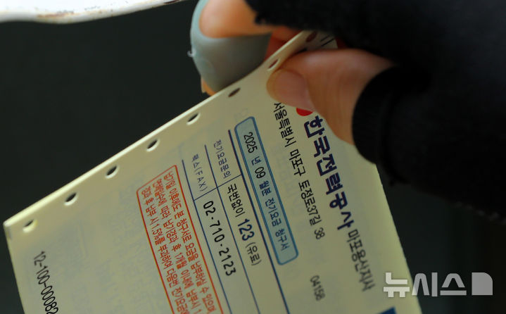 [서울=뉴시스] 김혜진 기자 = 22일 서울 시내 한 주택가에 관계자가 전기요금고지서를 배달하고 있다.2025.09.22. jini@newsis.com