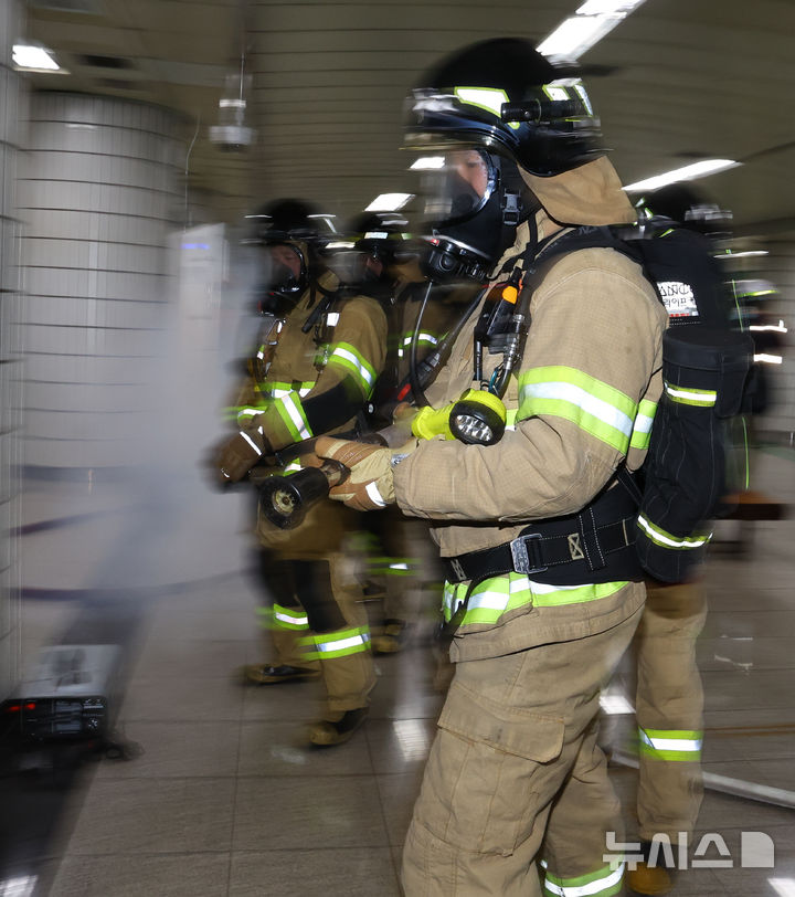 [서울=뉴시스] 최진석 기자 = 22일 서울 영등포구 여의나루역 일대에서 열린 2025 서울시 재난대응 안전한국훈련에서 소방대원들이 방수를 위해 준비작업을하고 있다. 2025.09.22. myjs@newsis.com