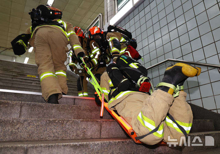 [서울=뉴시스] 최진석 기자 = 소방대원들이 22일 서울 영등포구 여의나루역 일대에서 열린 2025 서울시 재난대응 안전한국훈련에서 부상 소방대원 이송 시범을 보이고 있다. 2025.09.22. myjs@newsis.com