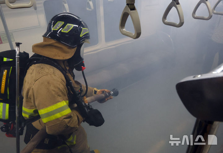 [서울=뉴시스] 최진석 기자 = 22일 서울 영등포구 여의나루역 일대에서 열린 2025 서울시 재난대응 안전한국훈련에서 소방대원들이 전동차 화재 훈련을 하고 있다. 2025.09.22. myjs@newsis.com