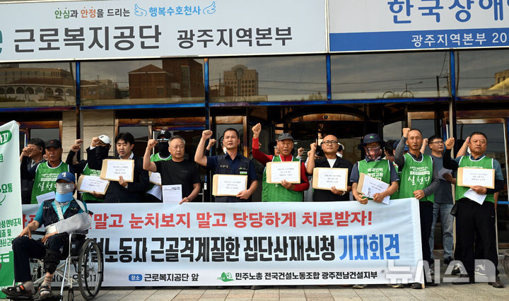 [광주=뉴시스] 이현행 기자 = 민주노총 전국건설노동조합 광주전남건설지부가 23일 오전 광주 서구 근로복지공단 광주지역본부 앞에서 건설노동자 근골격계질환 집단산재 신청 기자회견을 열고 구호를 외치고 있다. 2025.09.23. lhh@newsis.com