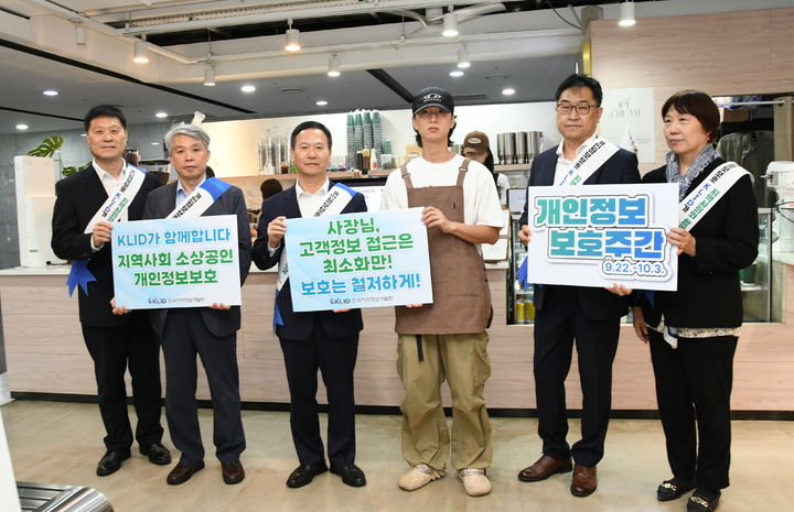 [수원=뉴시스] 박덕수 원장(왼쪽부터 세번째)을 비롯한 임직원, 커피 전문점 관계자가 개인정보보호 안내 팻말을 들고 기념 촬영을 하고 있다. (사진=개발원 제공) 2025.09.23. photo@newsis.com *재판매 및 DB 금지