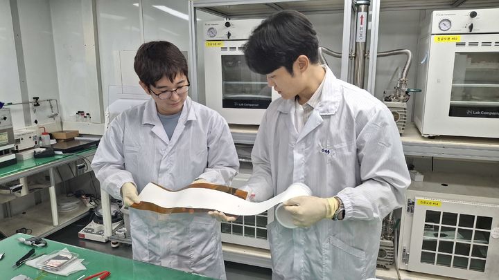 [대전=뉴시스] ETRI 연구진이 롤 형태로 제조된 대면적 고체전해질막의 품질과 외관 상태를 점검하고 있다.(사진=ETRI 제공) *재판매 및 DB 금지