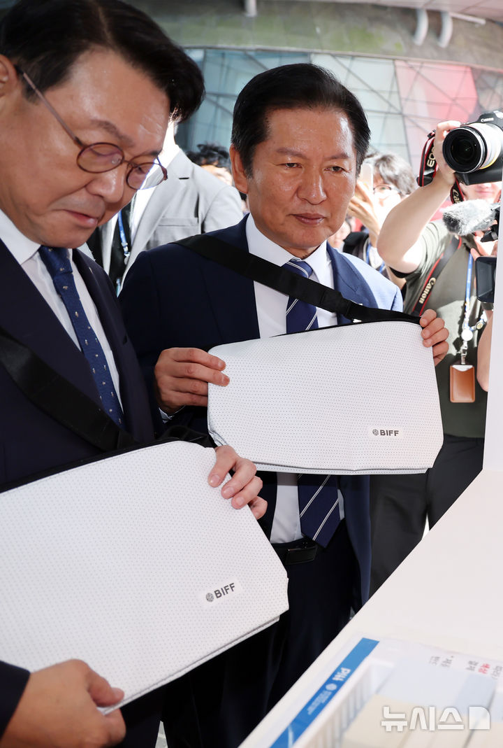  [부산=뉴시스] 하경민 기자 = 정청래 더불어민주당 대표가 23일 부산 해운대구 영화의전당에서 제30회 부산국제영화제 현장을 둘러보며 굿즈를 구입하고 있다. 2025.09.23. yulnetphoto@newsis.com