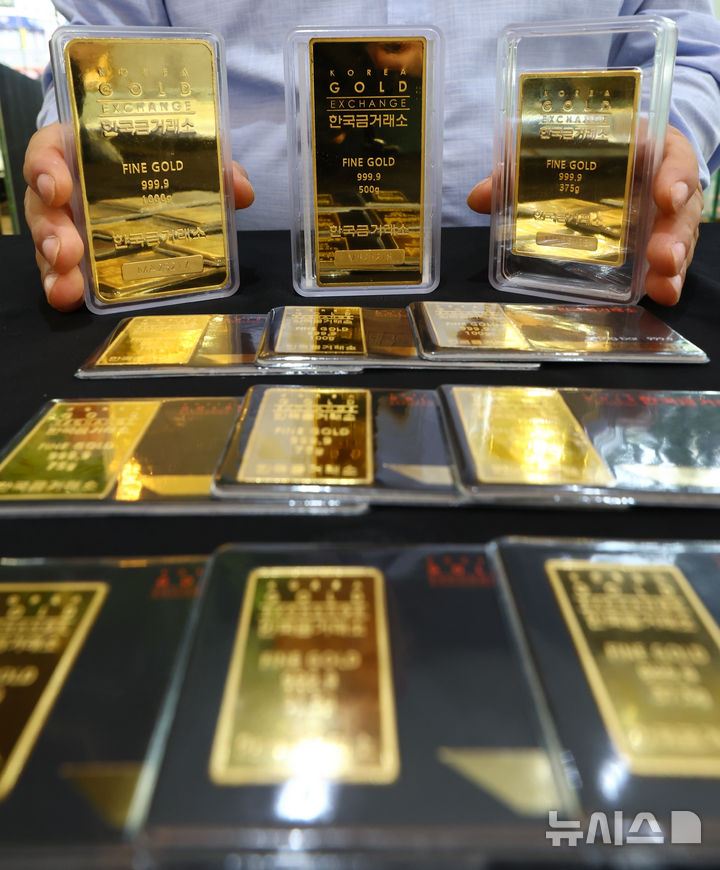 [서울=뉴시스] 황준선 기자 = 미국 연방준비제도(Fed·연준)의 지난주 금리 인하 영향으로 국제 금값이 사상 최고치를 경신한 23일 서울 종로구 한국금거래소에서 직원이 골드바를 들어보이고 있다. 이날 뉴욕상품거래소에서 12월 인도분 금 선물 종가는 온스당 3775.10달러로 전 거래일 대비 1.9% 상승하고 금 현물 가격은 미 동부시간 이날 오후 2시께 온스당 3747.08달러로 전 거래일 대비 1.7% 올라 금 선물 및 현물 가격 모두 사상 최고치 기록을 경신했다.2025.09.23. hwang@newsis.com