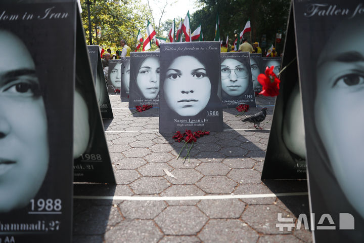 [AP/뉴시스] 23일 80차 유엔 총회가 개막된 뉴욕 유엔본부 앞에서 현 이란 정부 성토 시위가 벌여졌다. 사진은 시위 조직위가 전시한 이란 정부에 의해 살해된 민주화 운동가들 초상이다. 뒤편에 이란 국기가 보인다.