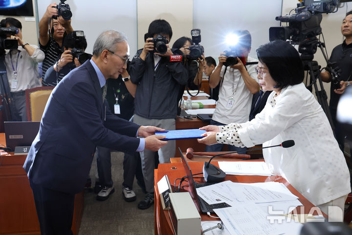 [서울=뉴시스] 김명년 기자 = 김영섭 KT 대표이사가 24일 오전 서울 여의도 국회 과학기술정보방송통신위원회 전체회의에서 열린 대규모 해킹사고(통신·금융) 관련 청문회에서 선서를 마치고 최민희 위원장에게 선서문을 제출하고 있다. 2025.09.24. kmn@newsis.com