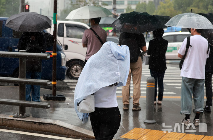 [서울=뉴시스] 이영환 기자 = 비가 내린 24일 오후 서울 종로구 광화문 네거리에서 한 시민이 옷으로 몸을 감싸며 걸어가고 있다. 2025.09.24. 20hwan@newsis.com