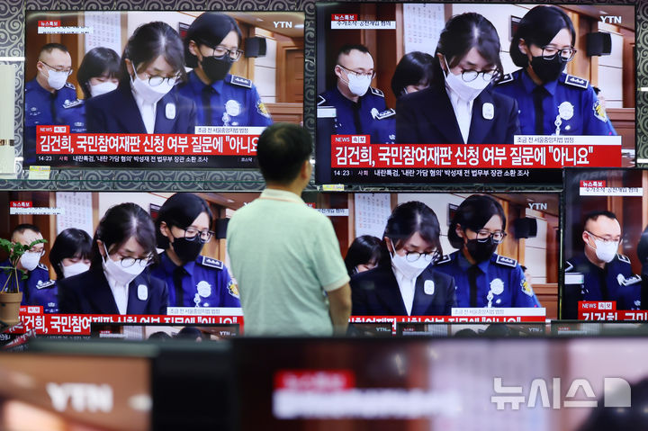 [서울=뉴시스] 김진아 기자 = 24일 서울 용산구 전자랜드 가전매장에서 한 시민이 자본시장법 위반, 정치자금법 위반 등 혐의로 구속기소 된 김건희 여사의 첫 재판 출석 중계방송을 지켜보고 있다. 2025.09.24. bluesoda@newsis.com