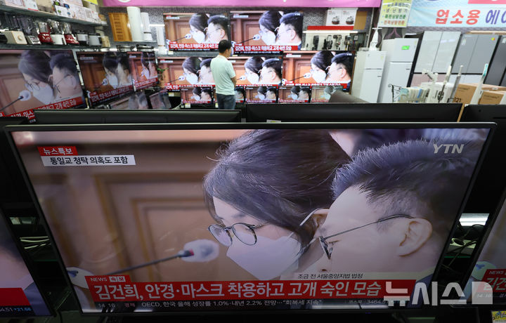 [서울=뉴시스] 김진아 기자 = 24일 서울 용산구 전자랜드 가전매장에서 한 시민이 자본시장법 위반, 정치자금법 위반 등 혐의로 구속기소 된 김건희 여사의 첫 재판 출석 중계방송을 지켜보고 있다. 2025.09.24. bluesoda@newsis.com
